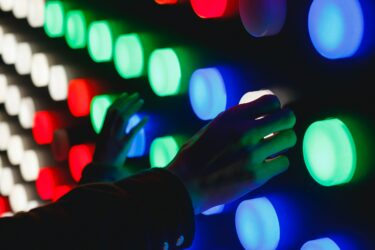 Neon style buttons touched by human hands
